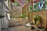 Outside shower surrounded by lush tropical foliage.